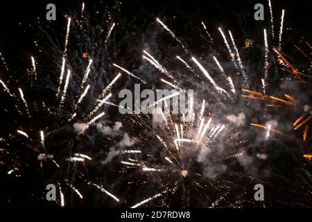 Goldene Strahlen von Feuerwerk auf schwarzem Hintergrund. Festliche Nacht Hintergrund. Stockfoto