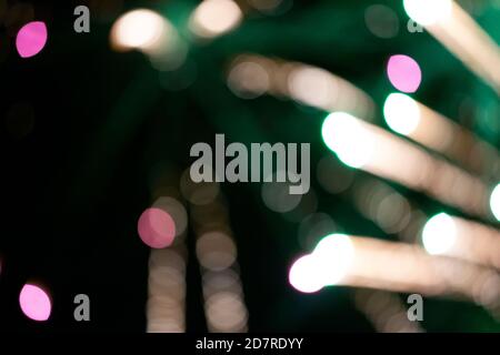 Auf schwarzem Hintergrund, goldene und grüne verschwommene Streifen und Bokeh-Flecken. Festlicher dunkler Hintergrund. Stockfoto