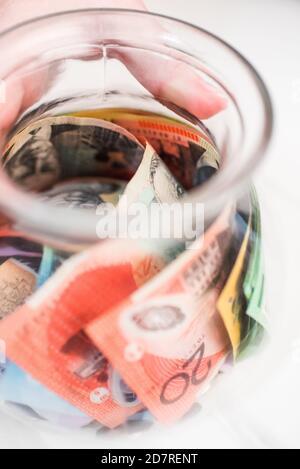 Vertikale Nahaufnahme von australischen Dollar-Banknoten in einem transparenten Glas Stockfoto