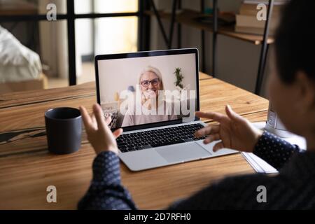 Studentin spricht mit reiferem Coach in einem Videoanruf Stockfoto