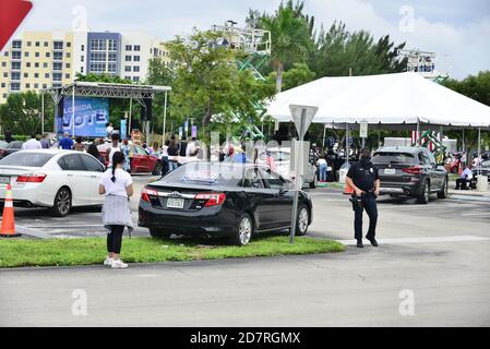 North Miami, Florida, USA. Okt. 2020. K9 Polizeibeamter Morejon steht Wache als ehemaliger US-Präsident Barack Obama spricht zur Unterstützung des demokratischen Präsidentschaftskandidaten Joe Biden während einer sozialen Distanz Drive-in-Rallye am 24. Oktober 2020 in North Miami, Florida. Obama kämpft für seinen ehemaligen Vizepräsidenten vor der Wahl am 3. November. Quelle: Mpi10/Media Punch/Alamy Live News Stockfoto