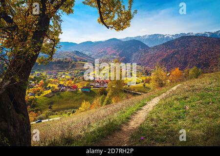 Atemberaubende Herbstlandschaft mit Bergdorf und Zarnesti Schlucht im Hintergrund, Magura, Siebenbürgen, Rumänien, Europa Stockfoto