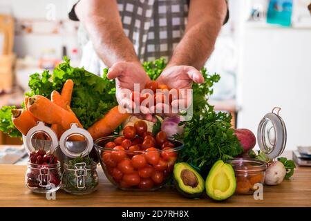 Gesunde Ernährung Lebensstil mit Menschen und gemischtes Gemüse und Avocado Auf einem Holztisch - Konzept von Mensch und Küche Mit farbiger Jahreszeit frisches vegetari Stockfoto