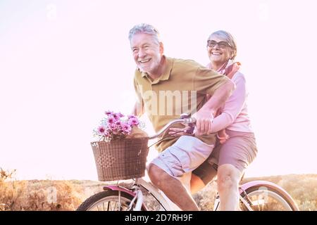 Fröhliche ältere Paare genießen die Freizeitaktivitäten im Freien Zusammen Fahrrad fahren und viel lachen - glücklich Ältere aktive Lebensweise mit ca. Stockfoto