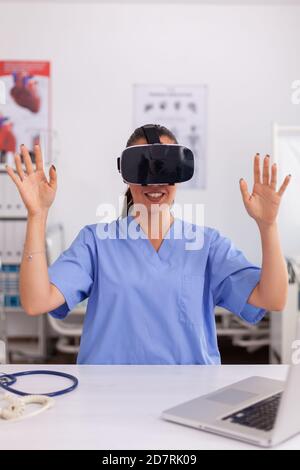 Medizinische Krankenschwester erleben virtuelle Realität mit vr Brille im Krankenhaus Büro. Therapeut mit medizinischen Innovation Geräte Geräte Brille, Zukunft, Medizin, Arzt, Gesundheitswesen, professionoanl, Vision, Simulator. Stockfoto