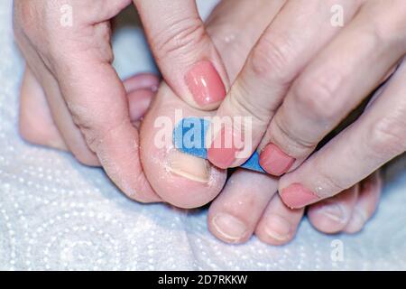 Nahaufnahme der Zehen von Frauen in einem Spa bei einer Pediküre. In den Händen einer blauen Nagelfeile. Selektiver Fokus Stockfoto