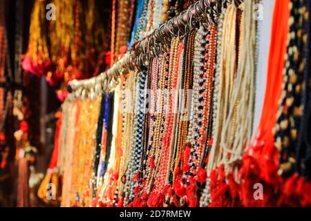 Handgemachte Ketten aus bunten Perlen und verschiedenen Designs hängen In einem Geschäft Stockfoto