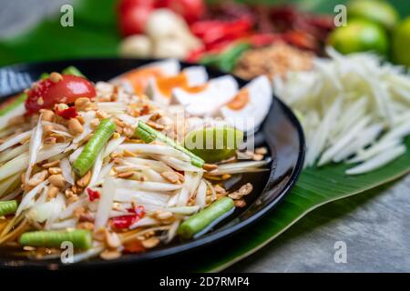 Som Tam Thai und Zutaten Papaya Salat mit gesalzenem Ei Thai Food Style auf Bananenblatt Hintergrund. Thai-Food-Konzept. Stockfoto