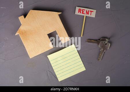 Holzmodell eines Hauses mit einem Mietschild und Schlüssel. Draufsicht. Stockfoto