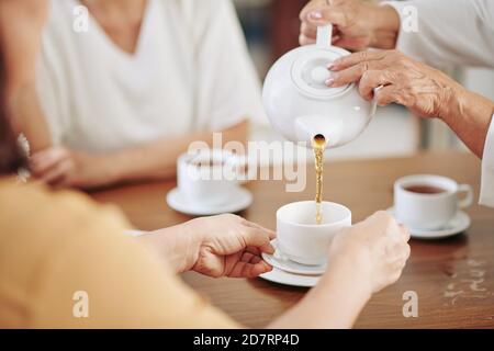 Ältere Frau gießt heißen Tee Stockfoto
