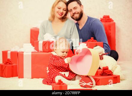 Bester Valentinstag. Rote Kästchen. Online einkaufen. Boxtag. Liebe und Vertrauen in die Familie. Bärtiger Mann und Frau mit kleinen Mädchen. Vater, Mutter und Tochter. Glückliche Familie mit Geschenk-Box. Stockfoto