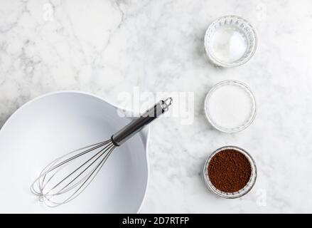 Dalgona Kaffeezutaten auf einem Marmortisch: Instant-Kaffee, Zucker und Wasser Stockfoto