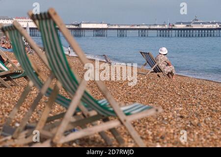 Urlauber und Touristen mit Liegestühlen am Kiesstrand in der Nähe des Palace Pier in Brighton. 20. Juli 1995. Foto: Neil Turner Stockfoto