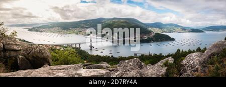 Panoramablick auf die Mündung der Ria de Vigo von Redondela an einem bewölkten Sommernachmittag, mit der kürzlich verlängerten Rande-Brücke im Zentrum und der AT Stockfoto