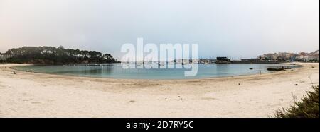 PORTONOVO, SPANIEN - 26. AUGUST 2020: Weitwinkelansicht des Strandes und Sporthafens von Portonovo in der Ria de Pontevedra in der Abenddämmerung, Spanien. Stockfoto