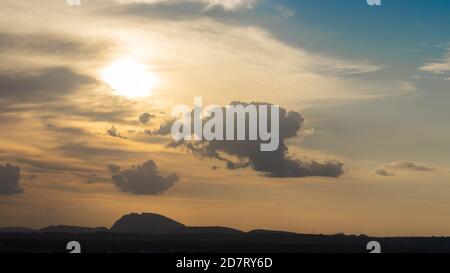 Silhouette der Hügel gegen schöne goldene Stunde Licht mit breiten Winkel und schöne Wolken Formation und ein Blick auf Blau Himmel Stockfoto