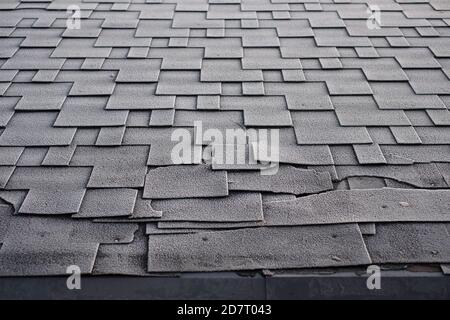 Schindeln Dachschaden mit Frost bedeckt. Nahaufnahme auf Asphalt Roofing Schindeln Hintergrund. Dachschindeln - Dacheindeckung. Stockfoto