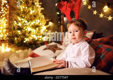 Junge las Bücher im Zimmer zu Weihnachten Stockfoto