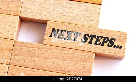 NÄCHSTER SCHRITT Wort auf Holzblock geschrieben. Schritt Text auf Tisch, Konzept Stockfoto
