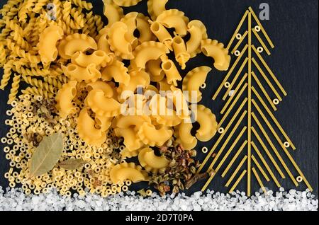 Weihnachtsbaum mit italienischen Spaghetti mit Salz auf Schiefergrund gemacht. Neujahr Hintergrund mit Pasta gemacht. Stockfoto