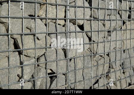 Dekorative Gabion Zaun ist aus Naturstein und Metallgeflecht. Stockfoto