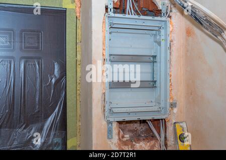 Installation der Spannungsschalttafel in der Wand vor der kompletten Montage. Elektrischer Hintergrund. Stockfoto