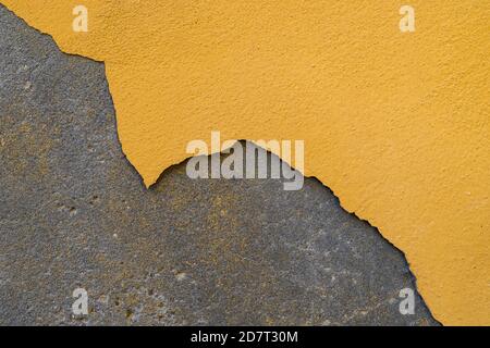 Die Farbe blättert von der verputzten Wand. Das Gebäude muss repariert werden. Stockfoto