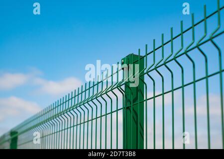 Stahlgitter Zaun mit Draht auf blauem Himmel Hintergrund gemacht. Montage der Abzäunung Stockfoto