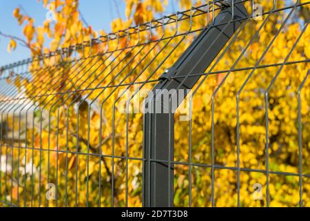 Stahlgitter Zaun mit Draht auf blauem Himmel Hintergrund gemacht. Montage der Abzäunung Stockfoto