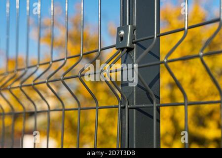 Stahlgitter Zaun mit Draht auf blauem Himmel Hintergrund gemacht. Montage der Abzäunung Stockfoto