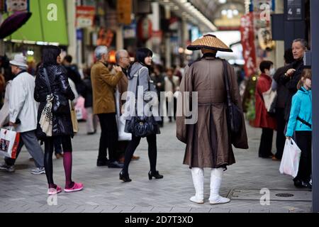 Japanischer Bettelmönch mit kegelförmigem Hut und Betteln in Asakusa-Station, Tokio, Japan 2012 Stockfoto