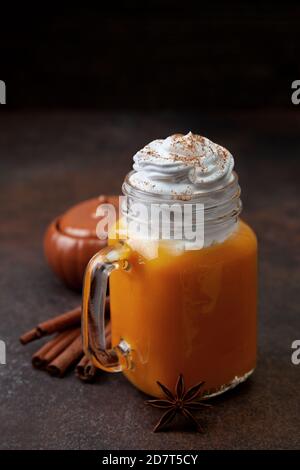 Kürbis Gewürz Latte in einem Einmachglas auf dunklem Hintergrund. Stockfoto
