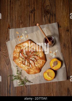 galette mit Pfirsich auf altem Holzhintergrund. Blick von oben. Stockfoto