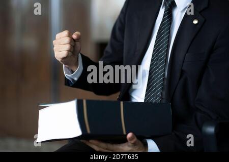 Anwalt hält Faust mit Gesetz Buch Stockfoto