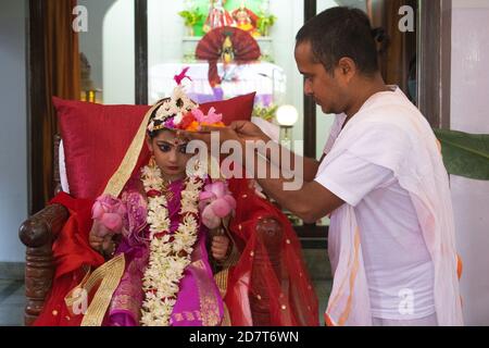 Kumari Puja oder Tochter Anbetung wird am neunten Tag (Navami) von Durga Puja durchgeführt. Es ist Ritual, in dem kleines Mädchen als Inkarnation von Shakti (Göttin Durga) verehrt wird. Es ist eine der besonderen Attraktionen von Durga Puja und sie feiern diesen Glauben als feierliche Verehrung junger Mädchen als Göttliche Mutter. Die in Safran gekleideten Mönche führen dieses Ritual durch, bei dem das Mädchen im ganga-Wasser gebadet und mit rotem und gelbem Saree gekleidet und mit Schmuck geschmückt wird. (Foto von Ribhu Chatterjee/Pacific Press) Stockfoto