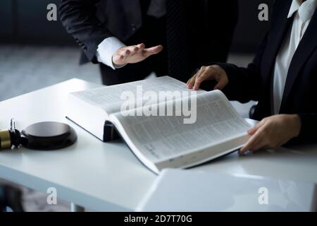 Anwälte diskutieren mit Gesetz Buch am Schreibtisch Stockfoto