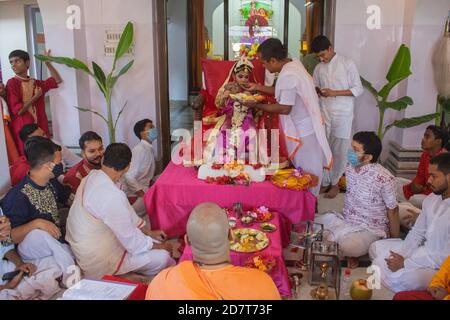 Kalyani, Indien. Okt. 2020. Kumari Puja oder Tochter Anbetung wird am neunten Tag (Navami) von Durga Puja durchgeführt. Es ist Ritual, in dem kleines Mädchen als Inkarnation von Shakti (Göttin Durga) verehrt wird. Es ist eine der besonderen Attraktionen von Durga Puja und sie feiern diesen Glauben als feierliche Verehrung junger Mädchen als Göttliche Mutter. Die in Safran gekleideten Mönche führen dieses Ritual durch, bei dem das Mädchen im ganga-Wasser gebadet und mit rotem und gelbem Saree gekleidet und mit Schmuck geschmückt wird. (Foto: Ribhu Chatterjee/Pacific Press) Quelle: Pacific Press Media Production Corp./Alamy Live News Stockfoto