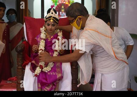 Kalyani, Indien. Okt. 2020. Kumari Puja oder Tochter Anbetung wird am neunten Tag (Navami) von Durga Puja durchgeführt. Es ist Ritual, in dem kleines Mädchen als Inkarnation von Shakti (Göttin Durga) verehrt wird. Es ist eine der besonderen Attraktionen von Durga Puja und sie feiern diesen Glauben als feierliche Verehrung junger Mädchen als Göttliche Mutter. Die in Safran gekleideten Mönche führen dieses Ritual durch, bei dem das Mädchen im ganga-Wasser gebadet und mit rotem und gelbem Saree gekleidet und mit Schmuck geschmückt wird. (Foto: Ribhu Chatterjee/Pacific Press) Quelle: Pacific Press Media Production Corp./Alamy Live News Stockfoto