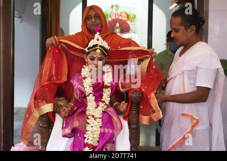 Kalyani, Indien. Okt. 2020. Kumari Puja oder Tochter Anbetung wird am neunten Tag (Navami) von Durga Puja durchgeführt. Es ist Ritual, in dem kleines Mädchen als Inkarnation von Shakti (Göttin Durga) verehrt wird. Es ist eine der besonderen Attraktionen von Durga Puja und sie feiern diesen Glauben als feierliche Verehrung junger Mädchen als Göttliche Mutter. Die in Safran gekleideten Mönche führen dieses Ritual durch, bei dem das Mädchen im ganga-Wasser gebadet und mit rotem und gelbem Saree gekleidet und mit Schmuck geschmückt wird. (Foto: Ribhu Chatterjee/Pacific Press) Quelle: Pacific Press Media Production Corp./Alamy Live News Stockfoto