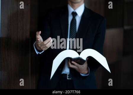 Zugeschnittenes Bild eines Rechtsanwalts, der ein Gesetzbuch hält Stockfoto