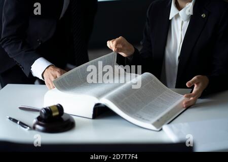 Anwälte diskutieren mit Gesetz Buch am Schreibtisch Stockfoto