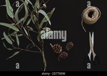 Blumenarrangement mit Eukalyptuszweigen auf schwarzem Hintergrund Stockfoto