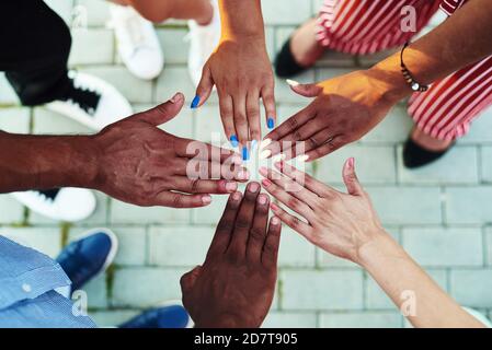 Schwarze Menschen mit Händen schlossen sich an. Gruppe von Personen, die Hände zusammenstapeln. Stockfoto