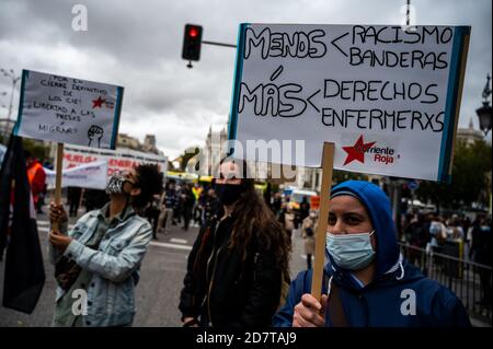 Madrid, Spanien. Oktober 2020. Ein Protestler, der ein Plakat mit der Aufschrift "weniger Rassismus, weniger Flaggen, mehr Rechte, mehr Krankenschwestern" trug, während einer Demonstration zur Unterstützung des öffentlichen Gesundheitssystems und den Rücktritt der Regionalpräsidentin von Madrid Isabel Diaz Ayuso für das Management der Coronavirus-Krise forderte. Quelle: Marcos del Mazo/Alamy Live News Stockfoto