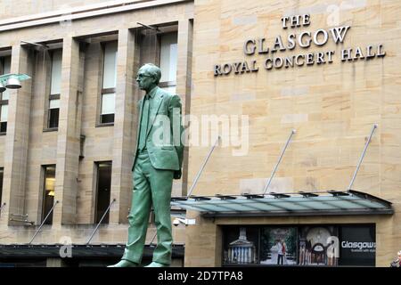 Glasgow, Schottland, Großbritannien. Statue des ersten Ministers Donald Dewar vor der Royal Concert Hall in Schottland.Glasgow, Buchanan Street.Statue von Donald Dewar am nördlichen Ende der Buchanan Street. Donald Dewar ein schottischer Politiker. Als Mitglied der Labour Party vertrat er Schottland 1966–1970 und dann ab 1978 im britischen Parlament. Bis zu seinem Tod 2000 war er Schottlands erster Minister. Seine Bronzestatue überblickt die Buchanan Street, eine der schönsten Durchgangsstraßen der Stadt, und steht auf den Stufen der Royal Concert Hall. Die Statue wurde am 7. Mai 2002 enthüllt. Stockfoto