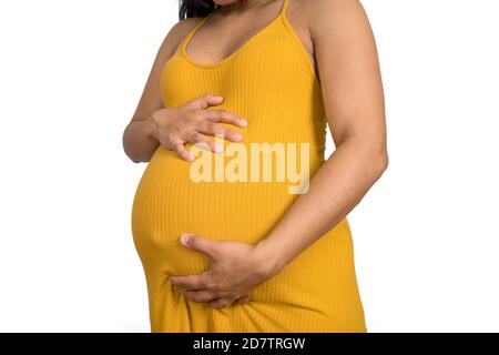 Nahaufnahme der schwangeren Frau, die ihren großen Bauch berührt. Schwangerschafts-, Mutterschafts- und Erwartungskonzept. Stockfoto