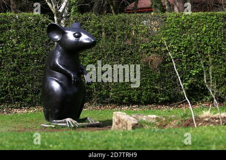 Alloway, Ayrshire, Schottland, Großbritannien. Eine riesige Maus Skulptur gewidmet Robert Burns Gedicht Ode an eine Maus. Dieser Gehweg verläuft parallel zur Straße für etwa 350 m und zeigt eine Reihe von zehn Wetterstürmen, die Szenen aus Robert Burns Gedicht Tam O'Shanter zusammen mit Skulpturen einschließlich einer 2 m hohen Maus, weit entfernt von der "wee, sleekit, Cowrin, tim'rous Beastie' beschrieben in Burns' Gedicht an eine Maus.zu den amüsanten Skulpturen gehört eine menschengroße Maus, die auf ihren Hinterbeinen steht. Diese wurde von Kenny Hunter modelliert und basiert auf einer echten Maus, die eines Tages von der Bildhauerkatze gefangen wurde Stockfoto