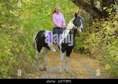 Tambow, Russland, 20. Oktober 2020: Kind Mädchen reiten andalusischen Dressurpferd bei der offiziellen Probe der Pokrovskaya Messe Ausstellung Stockfoto