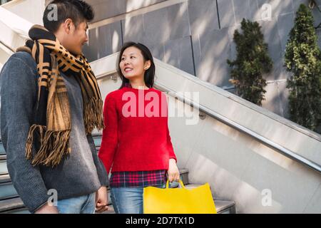 Portrait von schönen asiatischen Paar hält bunte Einkaufstaschen und genießen Shopping, Spaß zusammen in der Mall. Stockfoto