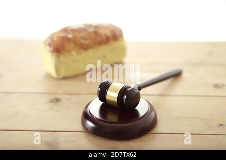 Gavel mit Brot auf Holztisch Stockfoto